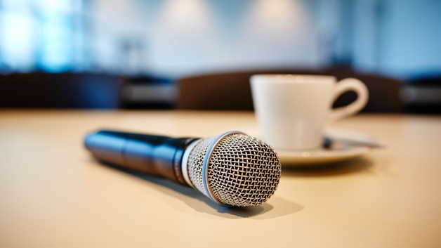 Press conference mood: microphone and coffe cup on a table.